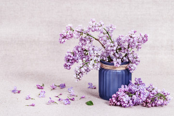 Bouquet of flowers in vase. Blossom of Lilacs scattered on table. Lilac close-up. Selective focus.