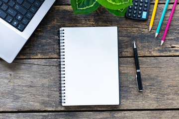 Empty notebook with smart phone and computer on wooden table top view.