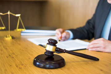 lawyer judge reading documents at desk in courtroom working on wooden desk background. gavel ...
