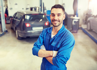 car service, repair, maintenance and people concept - happy smiling auto mechanic man or smith at...