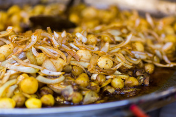 Young fried, whole rustic potatoes with onions close-up. Vending. Food Festival in Hungary