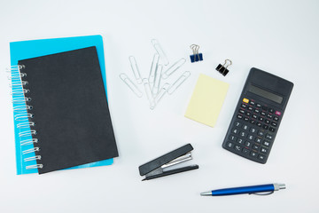  White office desk with calculator, notepad and sticker. Stationery on white background