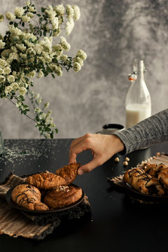 Naklejki FRESH BAKED CROISSANT  ON THE BLACK TABLE AND RUSTIC BACKGROUND