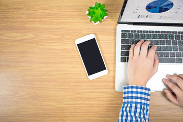 Man wear blue striped shirts, are typing on a laptop keyboard on a wooden table. Top view. Business concept.