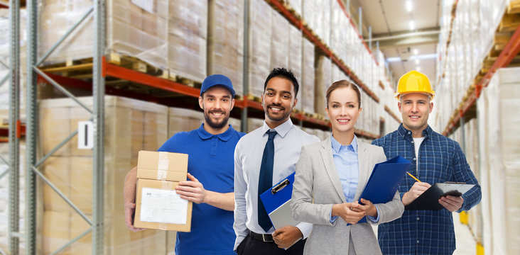 logistic business, delivery service and people concept - happy international team of employees over warehouse background