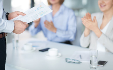 business, corporate and success concept - colleagues applauding to businessman with charts at office meeting or presentation