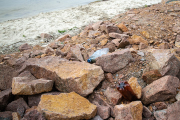 The world environmental pollution problem and issue with Garbage beach: Spilled garbage (rigid plastic bottles) on the rocky shore of the Kiev Sea