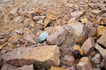 The world environmental pollution problem and issue with Garbage beach: Spilled garbage (rigid plastic bottles) on the rocky shore of the Kiev Sea