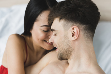 Fototapeta premium beautiful, happy asian woman embracing handsome smiling boyfriend