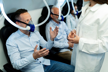 Happy male patient communicating with doctor during hyperbaric oxygen therapy.