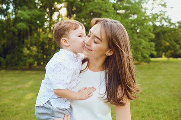 Mother and child play hugging in the park. 