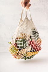 woman's hand holding a bag of mixed fruit and vegetables