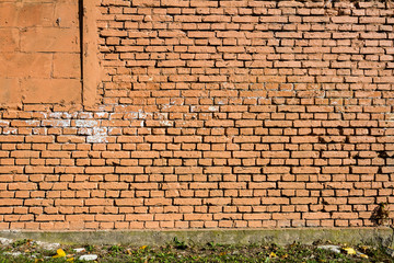 Old yellow brick wall part painted in brown