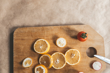 Healthy vegan food background with cutting board and lemon slices. Top view to organic food background with cutting board and lemon slices