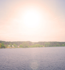 Beautiful sunset over a large lake in the village. Landscape evening summer.