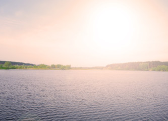 Beautiful sunset over a large lake in the village. Landscape evening summer.
