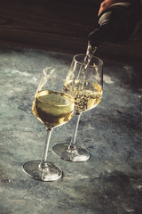 White wine pouring into glasses, close up