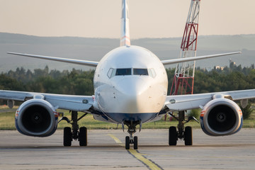 Commercial airplane standing on the airport runway. Passenger airplane landing or taking off.