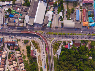 Crossing highway in rural area from a green plantation from a bird's eye view in Thailand, top view