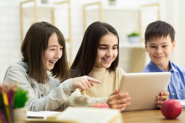 School Kids With Tablet Computer Having Fun On Break