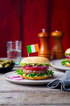 Burger with Irish flag on top. Wooden background. Copy space.