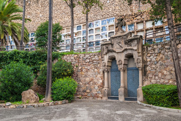 Fototapeta premium The stone wall with many graves and crypt on the Montjuic Cemetery, Barcelona, Catalonia, Spain