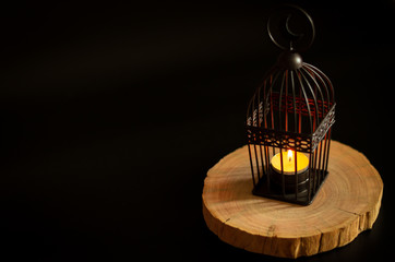 Beautiful Lantern that have moon symbol on top put on wooden tray with dark background for the Muslim feast of the holy month of Ramadan Kareem.