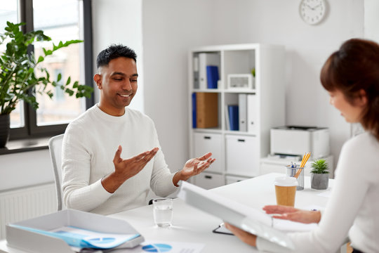 New Job, Business And Employment Concept - Smiling Indian Male Employee Having Interview With Female Employer Or Hr Manager At Office