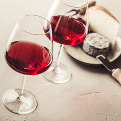 Red wine and cheese on concrete background, close up