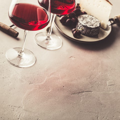 Red wine and cheese on concrete background