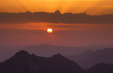 sonnenaufgang mit strahlen über den bergen