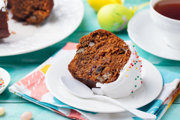 Easter cake on a white plate with colorful eggs. Blue wooden background. Close up.