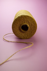 spool of thread burlap on a pink background.