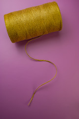 spool of thread burlap on a pink background.