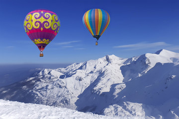 Colorful balloons flying over snow-covered mountains