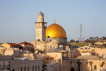 View of the Dome of the Rock and the Western Wall in the Old City during a sunny evening before sunset. Taken in Jerusalem, Israel.