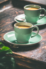 Cups of coffee and capsules, close up