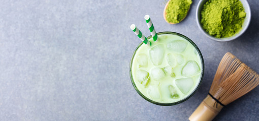 Matcha green tea ice latte with matcha powder and bamboo whisk. Top view. Copy space.