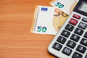 50 euros and a calculator on the table. Close-up.