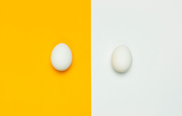 Creative food minimalistic background, Easter. White chicken eggs on yellow and gray background top view flat lay copy space. Natural healthy food and organic farming concept.