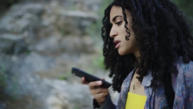 Black woman talking smartphone on nature