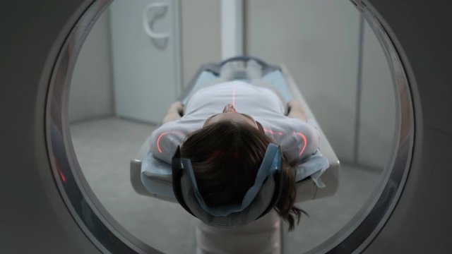 Female Patient On The Ct Or Mri Scanner Machine During X-Ray Process,