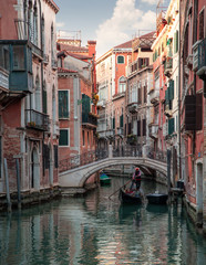 Fototapeta na wymiar A very beautiful canal in Venice with a gondola driving through the calm water