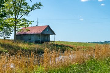 Rural old house barn reflected on pond water in northwest Arkansas, Ozark mountains, beautiful...