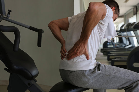 Man with Back Pain in Gym. Sports exercising injury