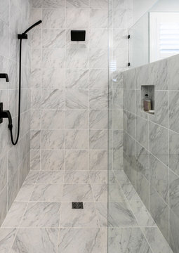 Luxury wheelchair accessible shower with marble floor and walls.