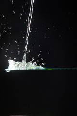 Obraz na płótnie Canvas Agua creando formas al caer sobre un cristal