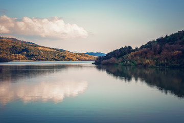 Autumn forest reflected in the water. Colorful autumn morning in the mountains.