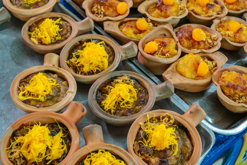Coconut mung bean custard dessert or Khanom Maw Kaeng in clay pot. Traditional Thai food freshly cooked for sale in the market. Street food in Thailand.