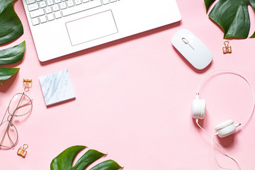 Business concept flat lay with a laptop on the pink background. Top view. Copy space